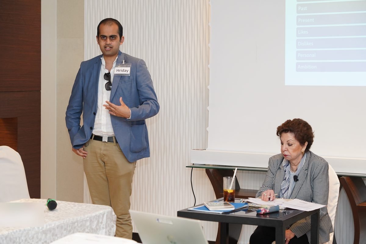 A participant presents while Sabira Merchant writes her assessment