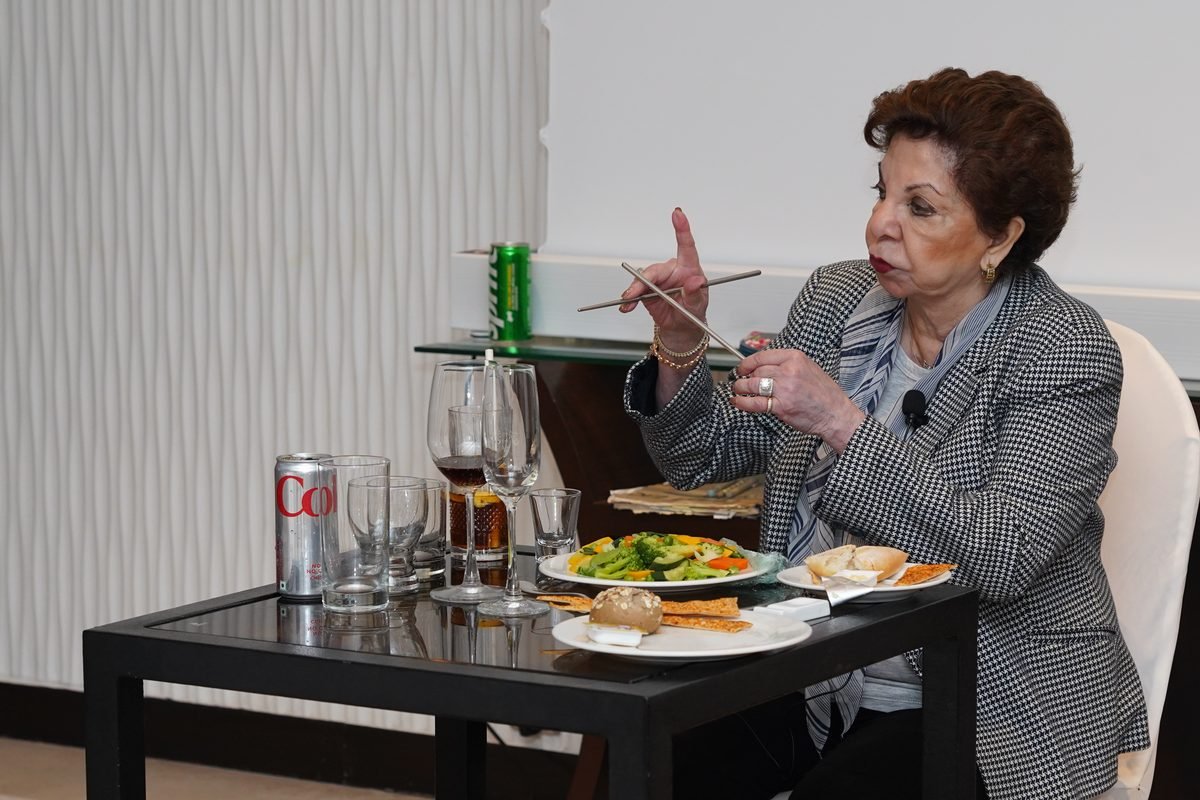Sabira Merchant holding up a fork beside a salad course