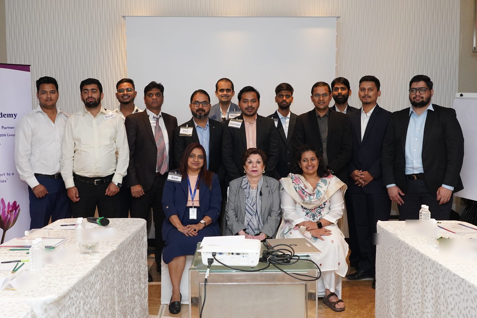 A group of participants standing and seated with Sabira Merchant at the end of a session