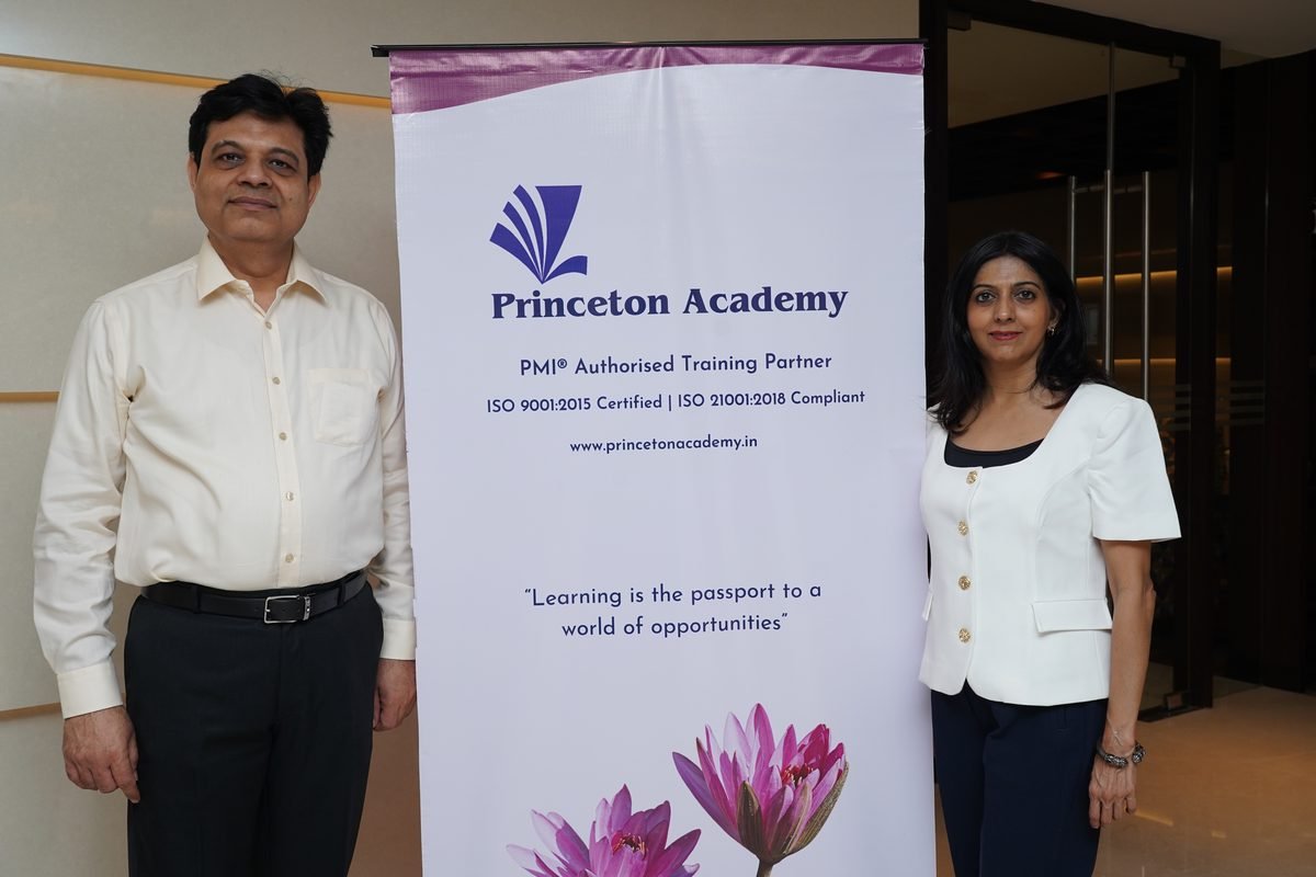 The two directors of Princeton Academy beside a Princeton Academy banner