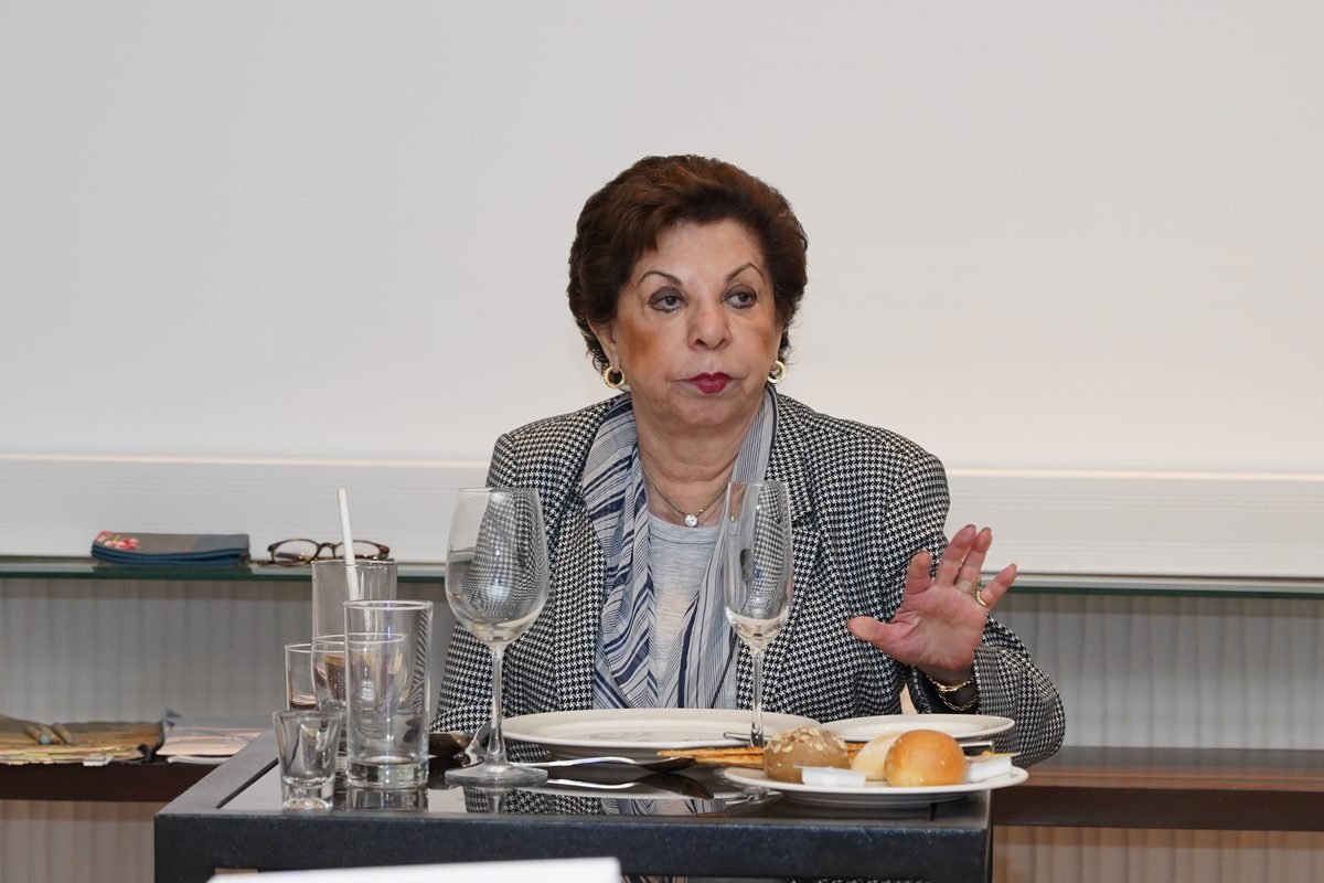Sabira Merchant gesturing as she explains a point at a laid table